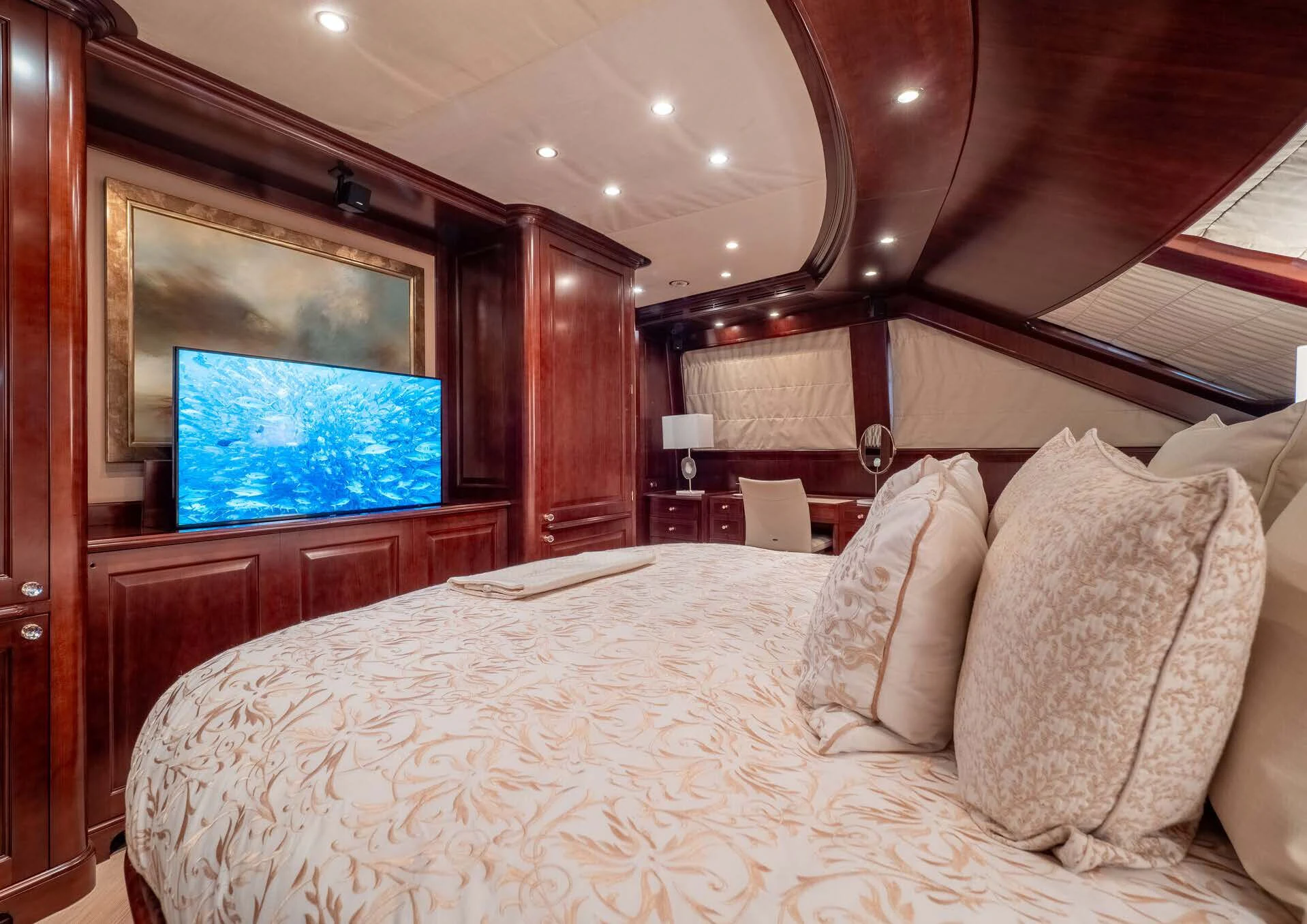 a bed with pillows and a television aboard GIORGIA I Yacht for Sale