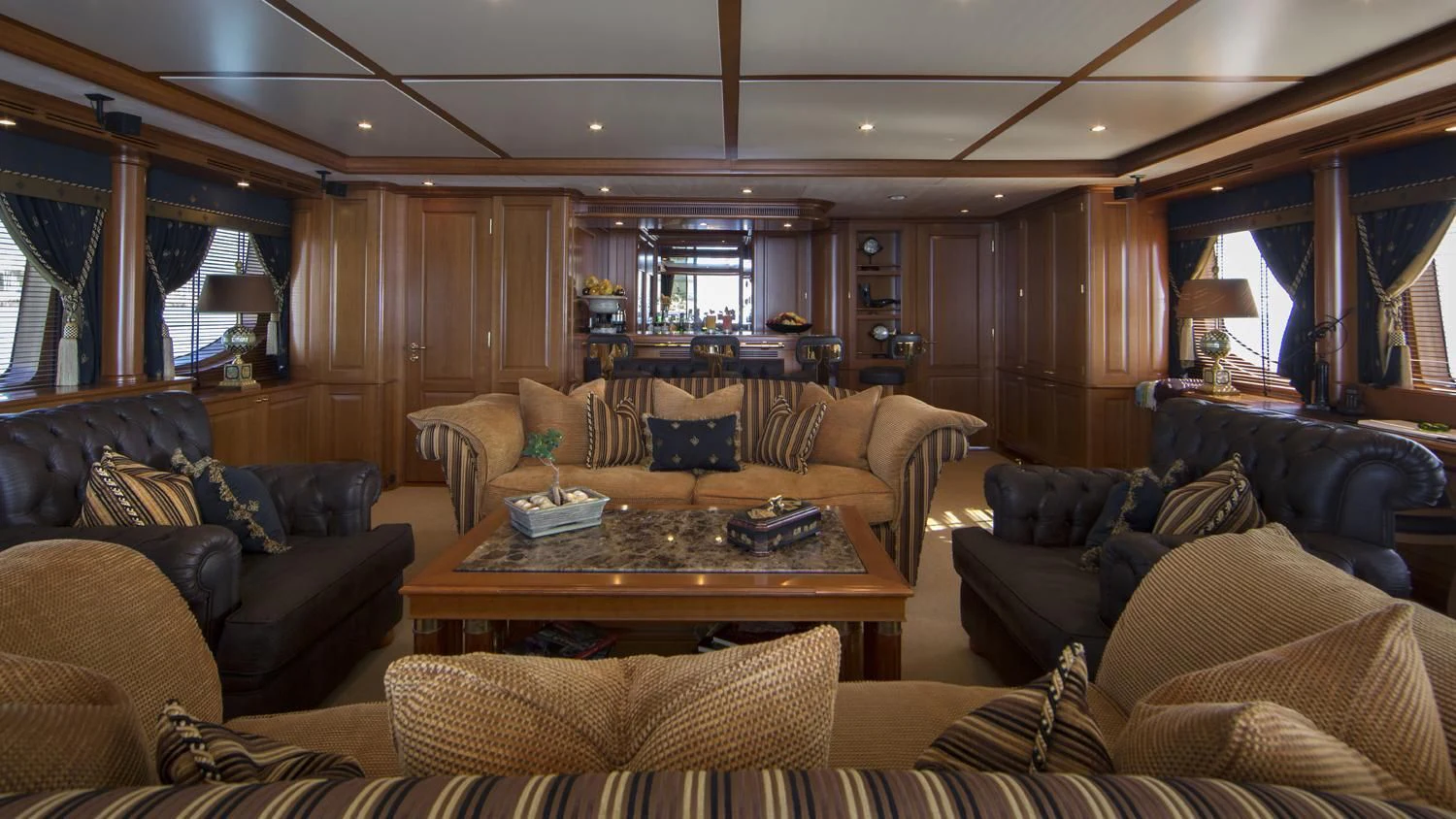 a living room with leather couches and a wood table aboard GIORGIA I Yacht for Sale