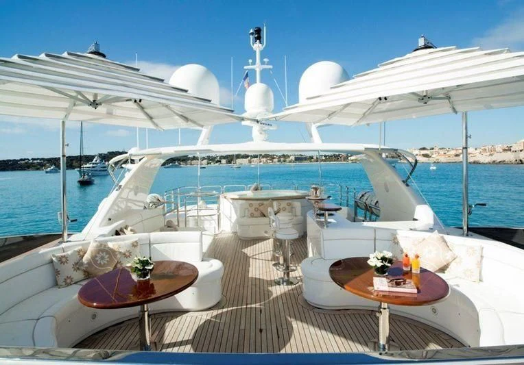 a deck with a table and chairs on it aboard GIORGIA I Yacht for Sale