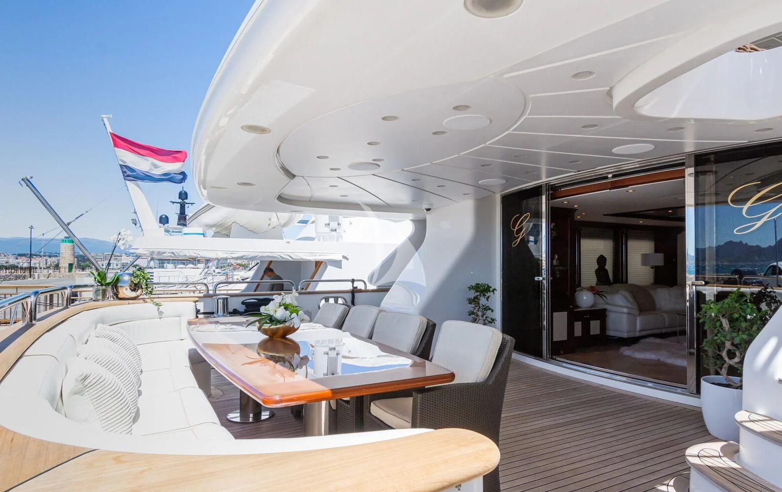 a large white boat with a table and chairs in front of it aboard GIORGIA I Yacht for Sale