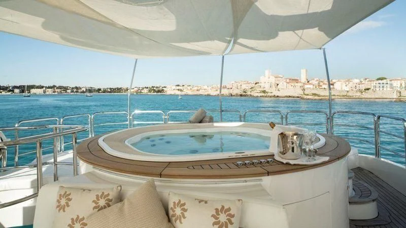 a large white lounge chair on a balcony overlooking a body of water aboard GIORGIA I Yacht for Sale