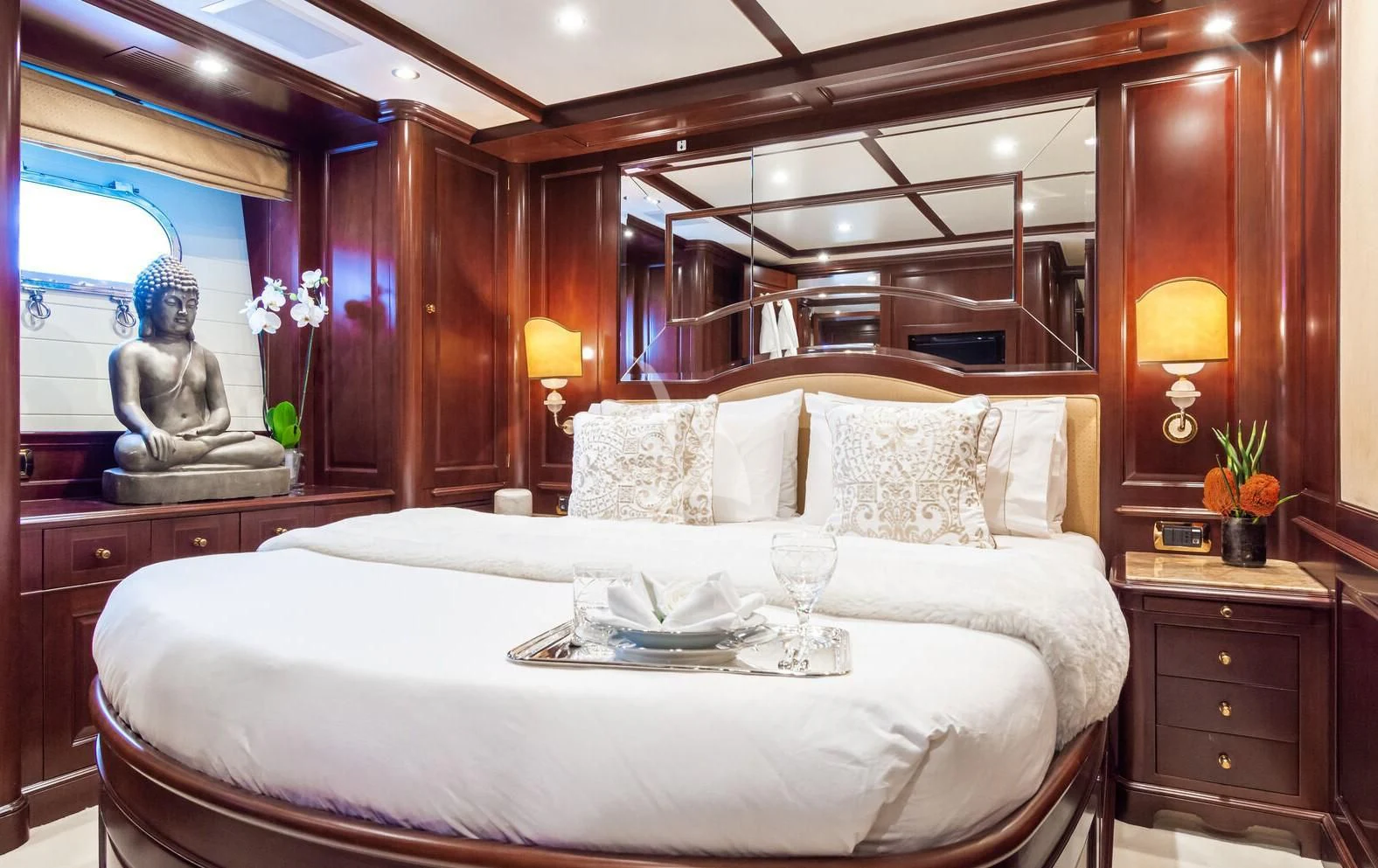 a bed with a white sheet and a table with a lamp and a window aboard GIORGIA I Yacht for Sale