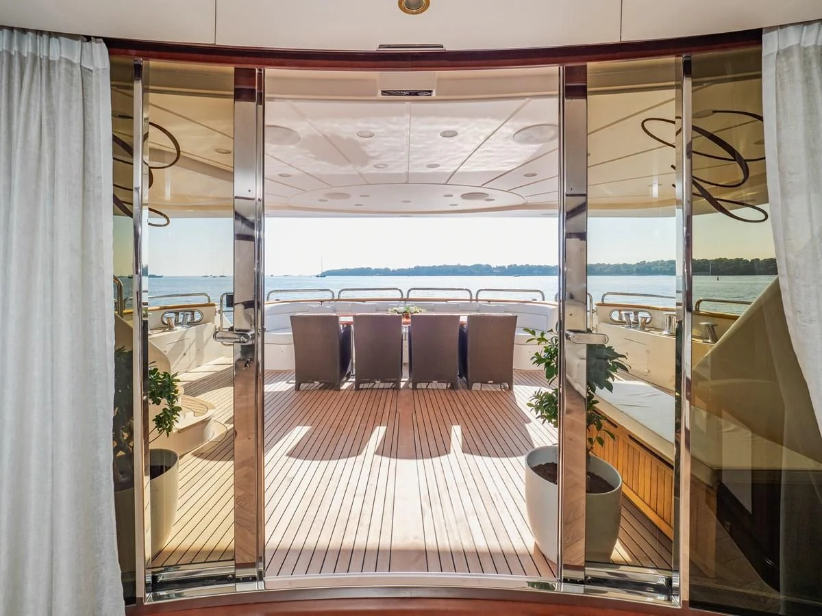 a long wooden walkway with a glass door and a balcony aboard GIORGIA I Yacht for Sale