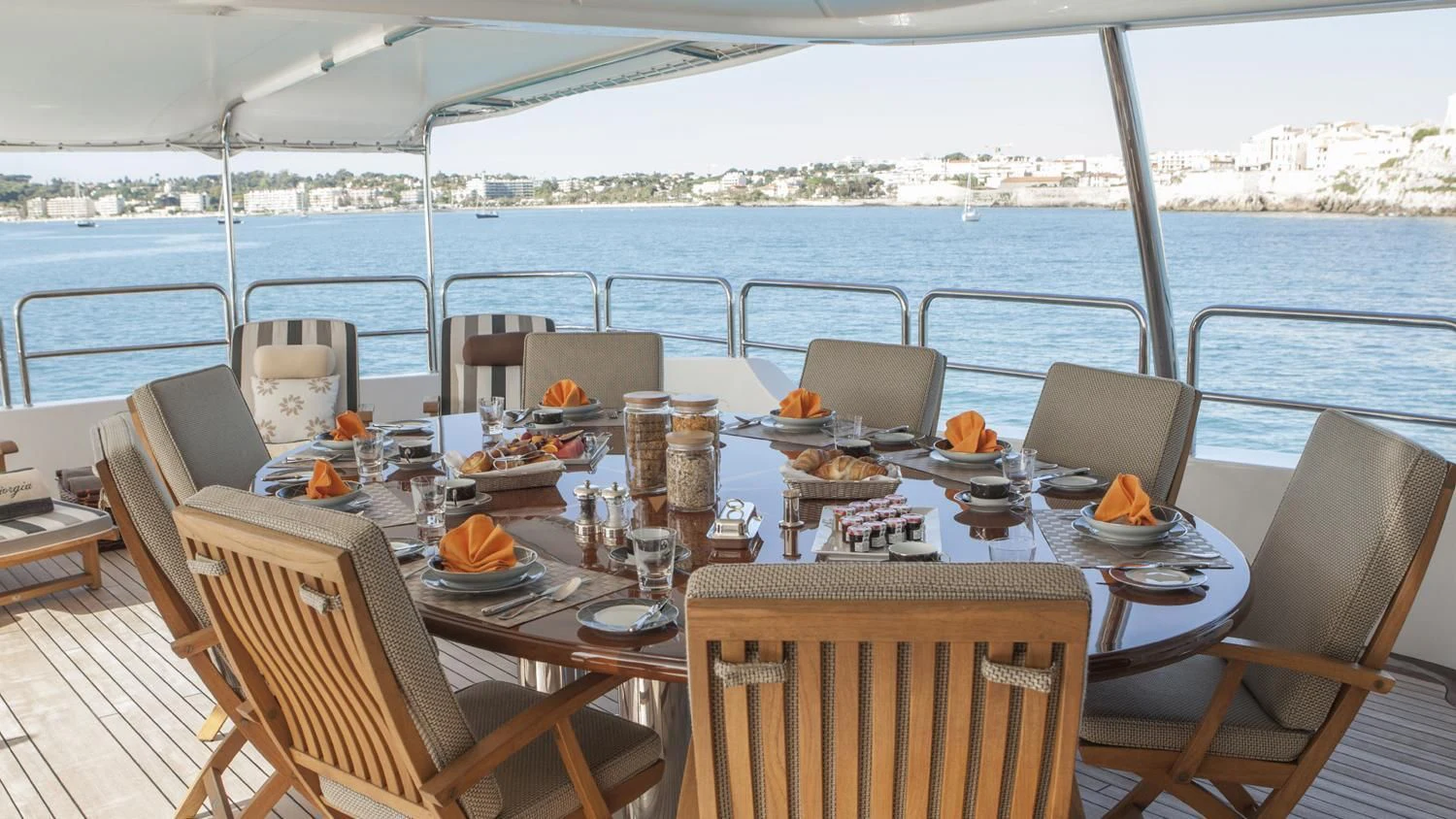 a table set for a meal on a deck overlooking a city aboard GIORGIA I Yacht for Sale