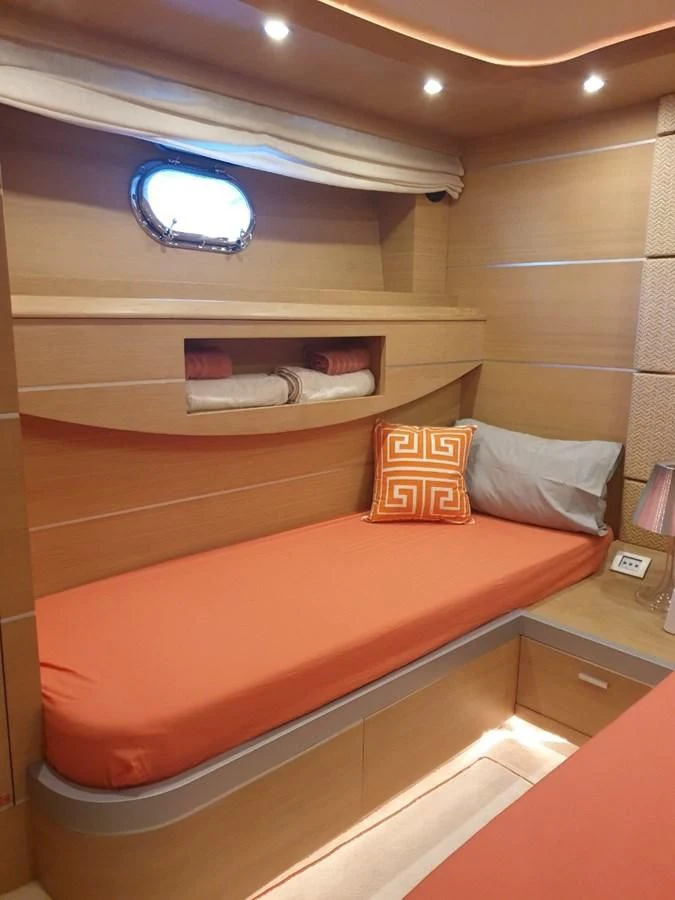 a bed with orange pillows aboard FOX Yacht for Sale