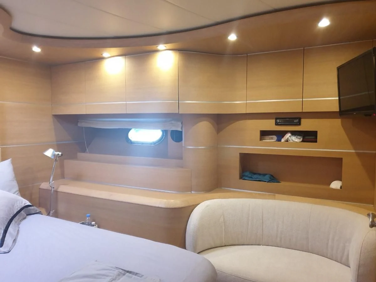 a room with a bed and a television aboard FOX Yacht for Sale
