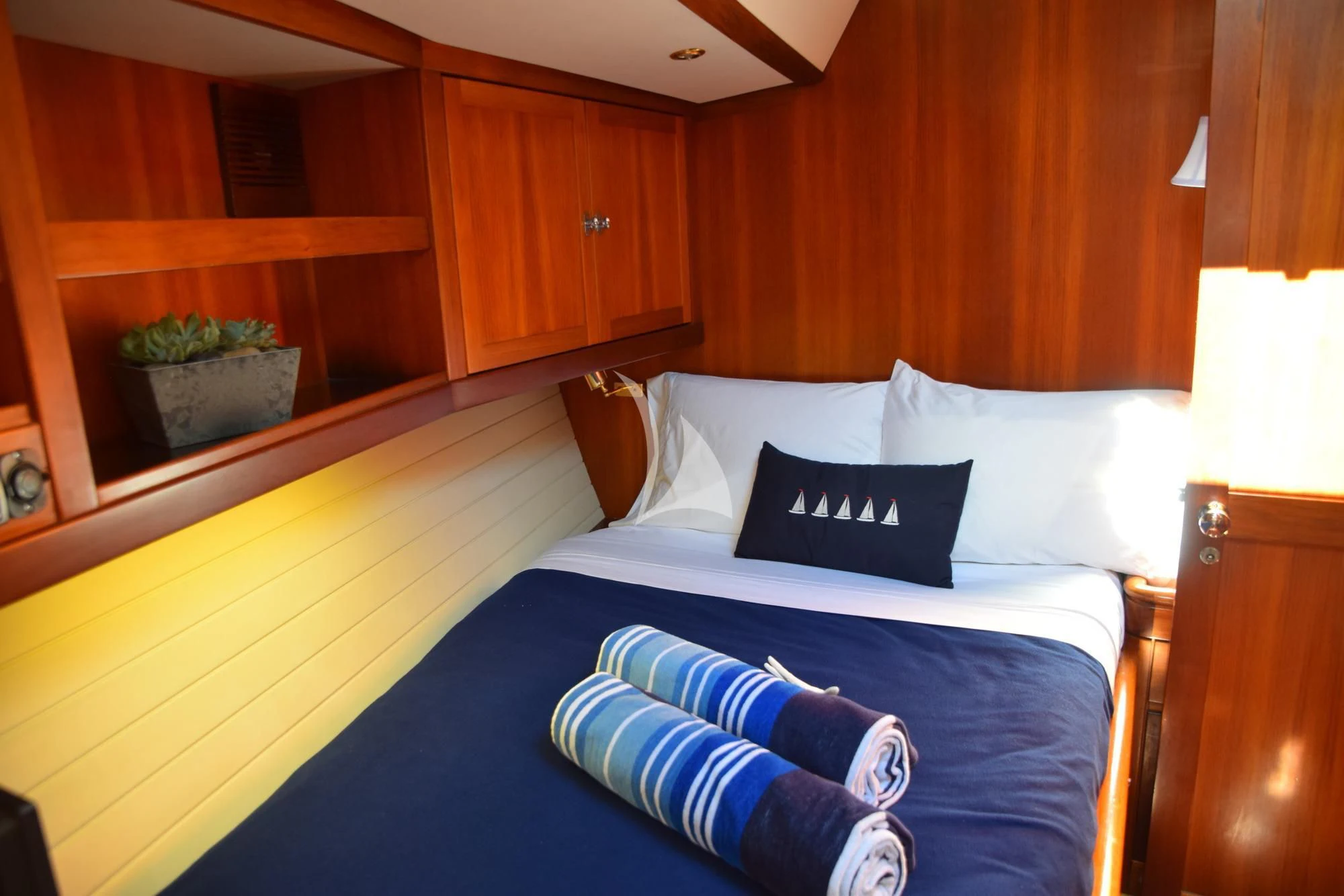a bed with blue and white pillows aboard LUNA DANNS Yacht for Sale