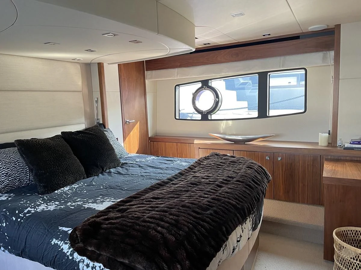 a bed with a black comforter and a tv on the wall aboard MOONLIGHT DRIVE Yacht for Sale