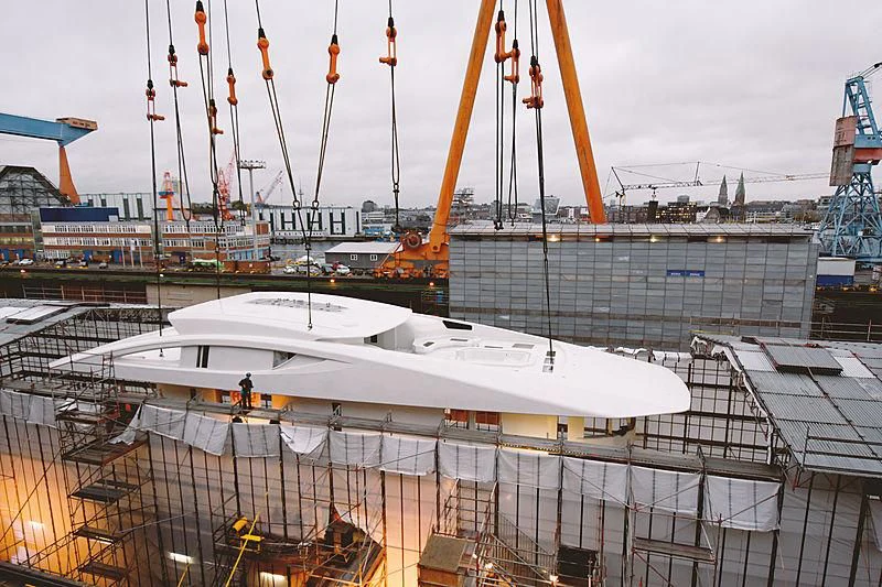 a large white boat in a harbor aboard BLACK SHARK Yacht for Sale