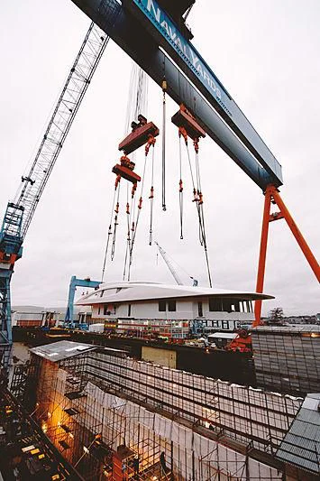 a large crane with a building in the background aboard BLACK SHARK Yacht for Sale
