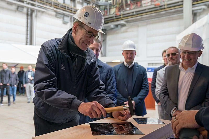 a person in a suit and hat signing a book aboard BLACK SHARK Yacht for Sale