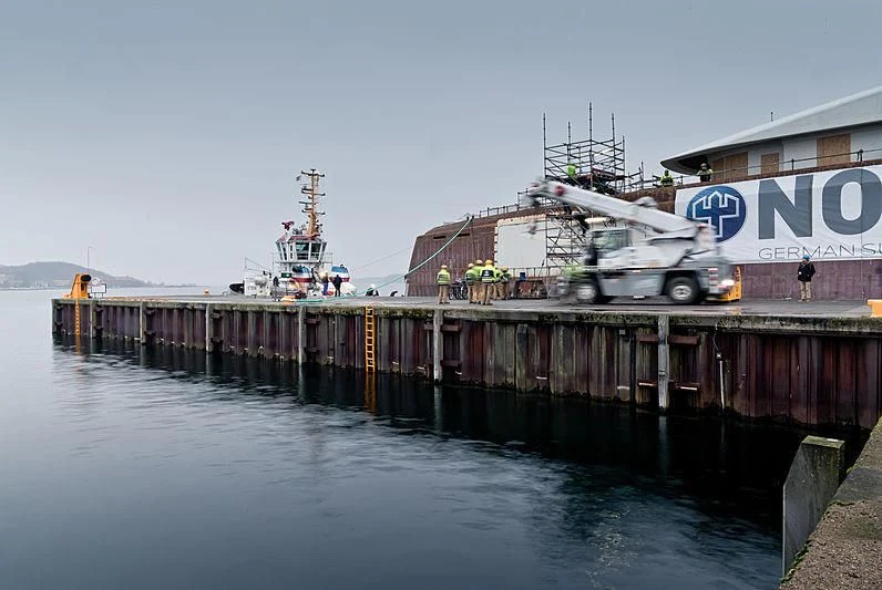 a large ship docked at a dock aboard BLACK SHARK Yacht for Sale