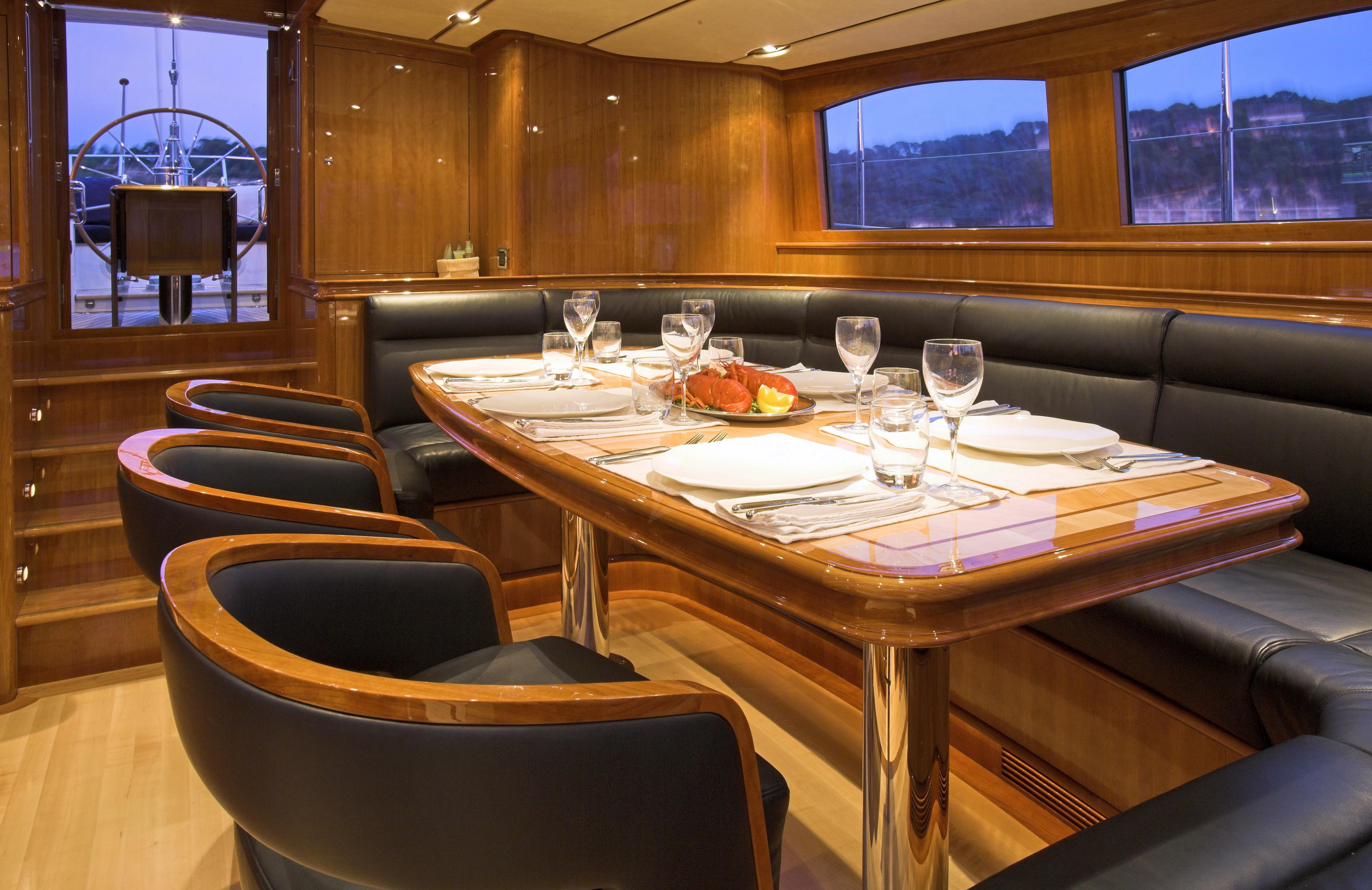 a table with wine glasses and plates aboard SEABISCUIT Yacht for Sale