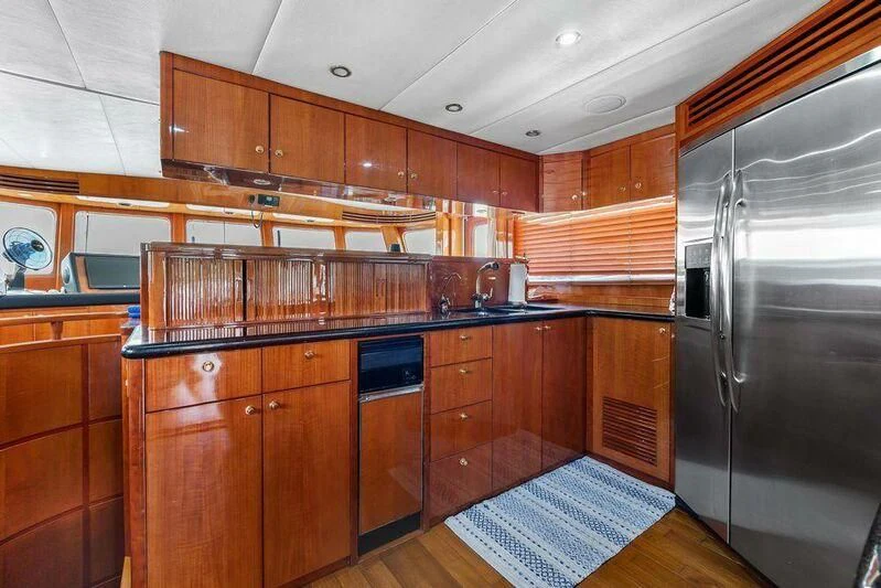 a kitchen with wooden cabinets aboard MENTORSHIP IV Yacht for Sale