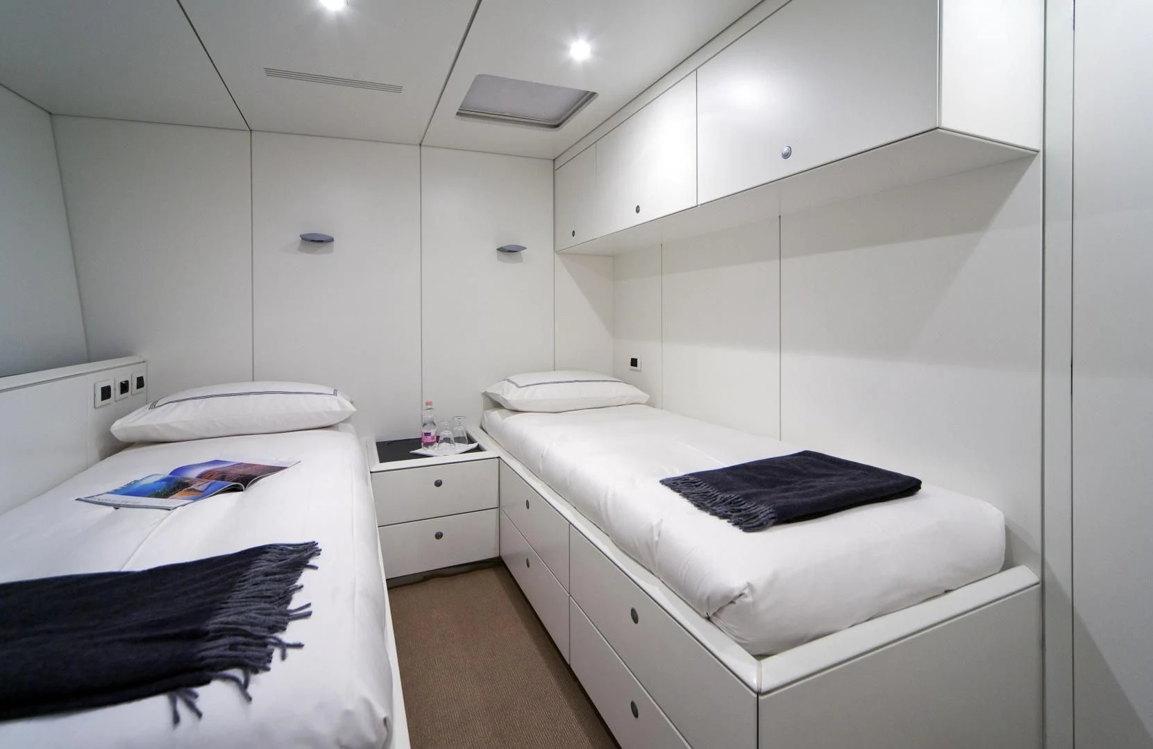 a white room with a bed and a black blanket aboard RUNNING ON FAITH Yacht for Sale