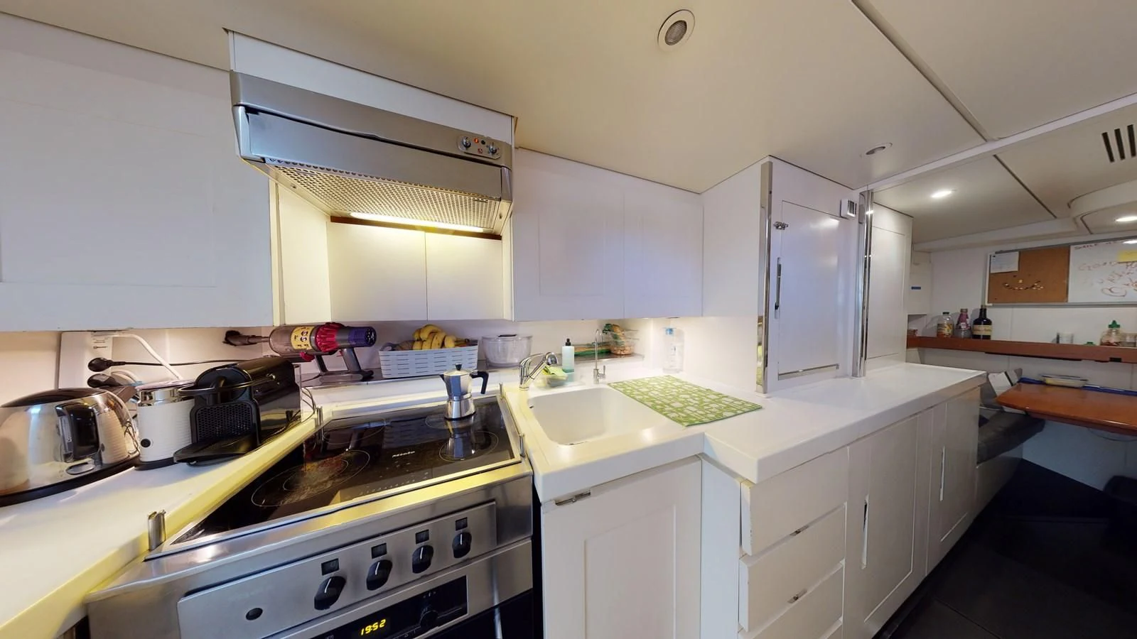 a kitchen with white cabinets aboard RUNNING ON FAITH Yacht for Sale