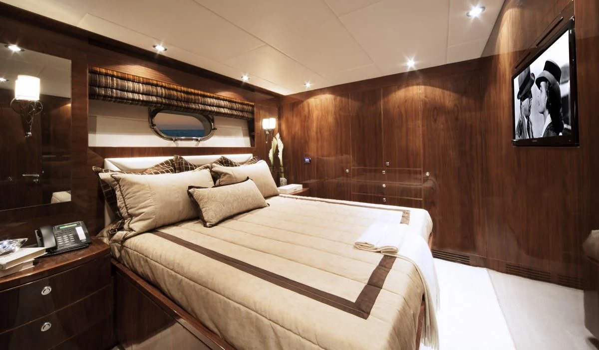 a bed with a wooden headboard aboard EBITDA Yacht for Sale