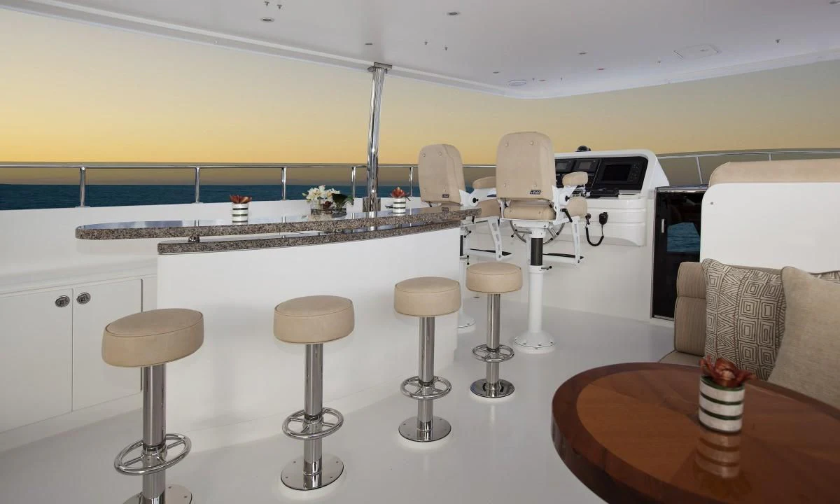 a room with stools and a table and chairs aboard EBITDA Yacht for Sale