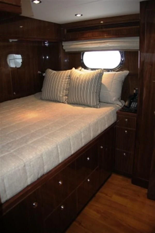 a bed with a wooden headboard aboard EBITDA Yacht for Sale