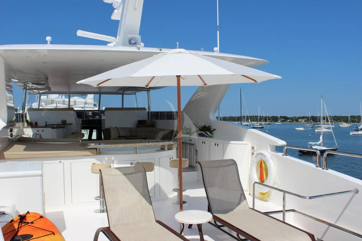 a boat with an umbrella aboard EBITDA Yacht for Sale