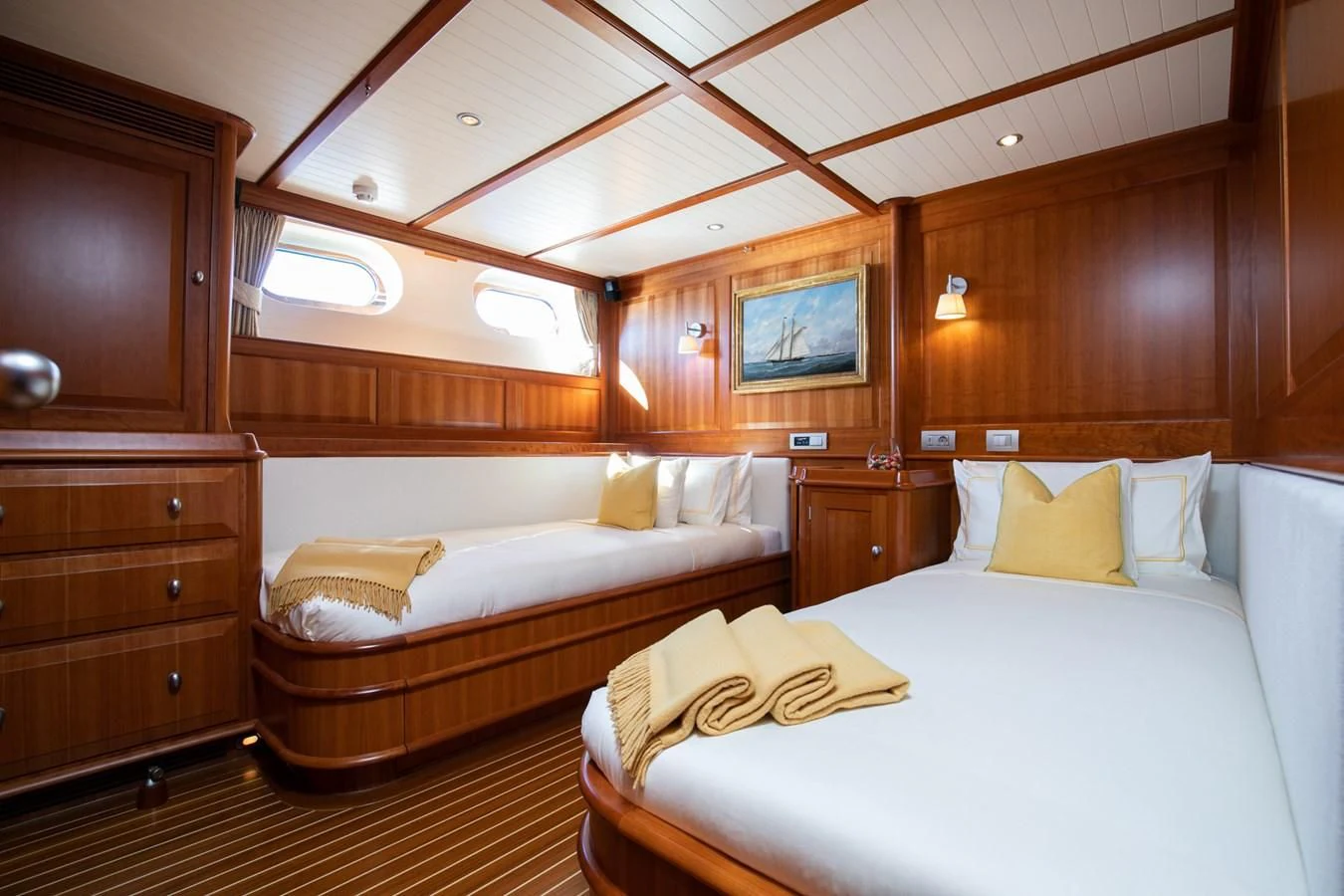 a room with a bed and a wood cabinet aboard PITUXIN VI Yacht for Sale