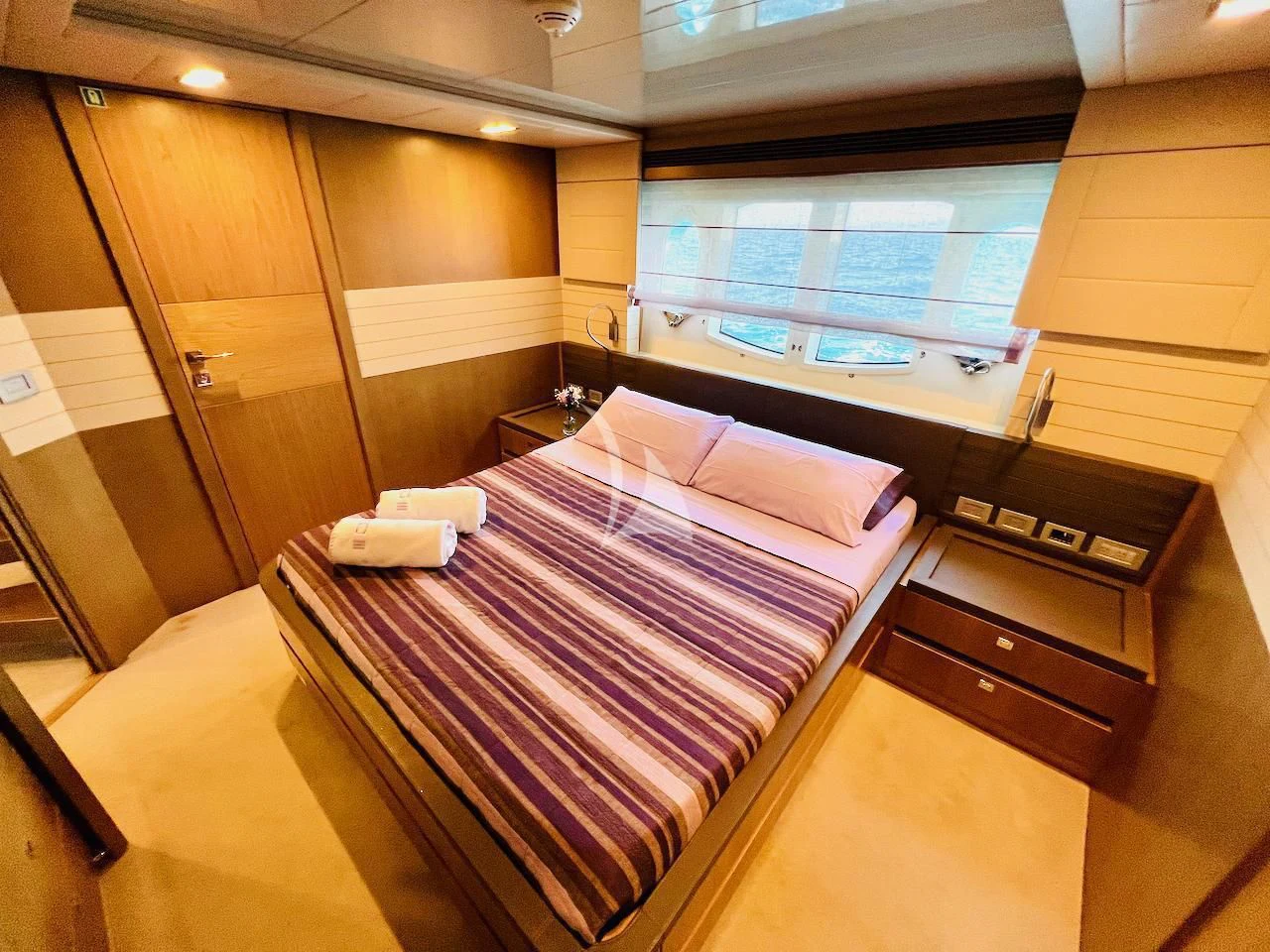 a room with a bed and a desk aboard NIKO III Yacht for Charter