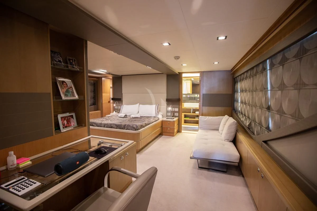 a bedroom with a bed and desk aboard NIKO III Yacht for Charter