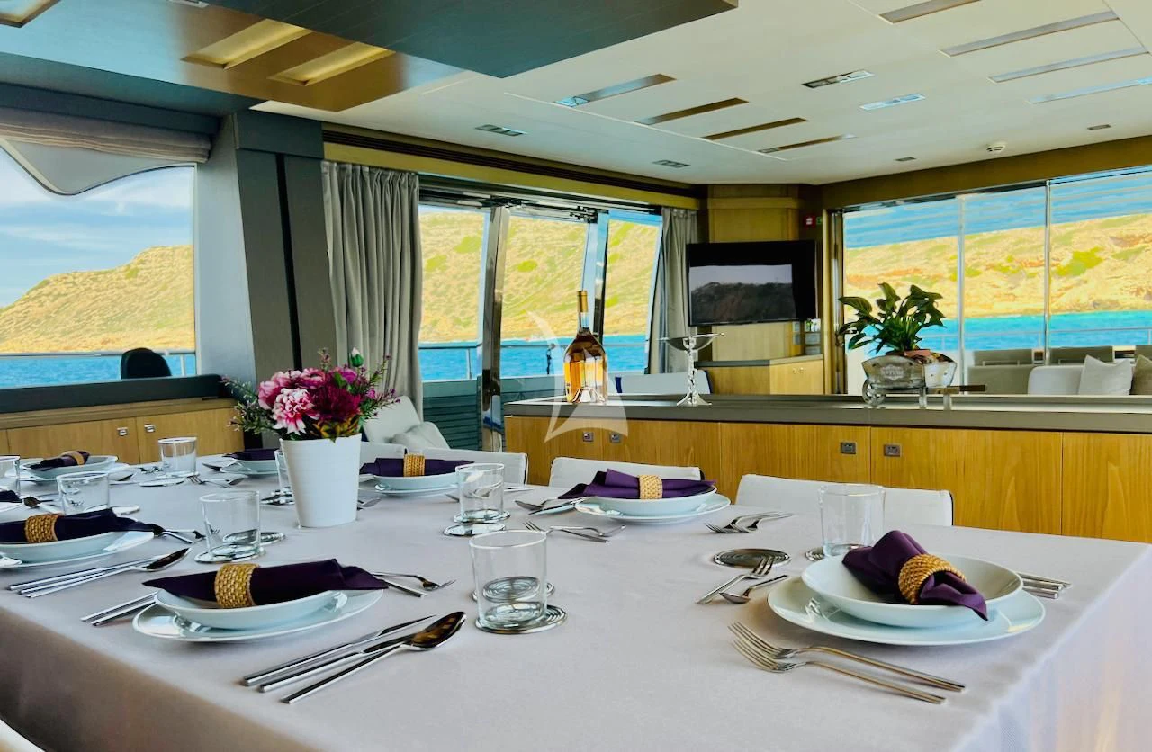 a table set with plates and glasses aboard NIKO III Yacht for Charter