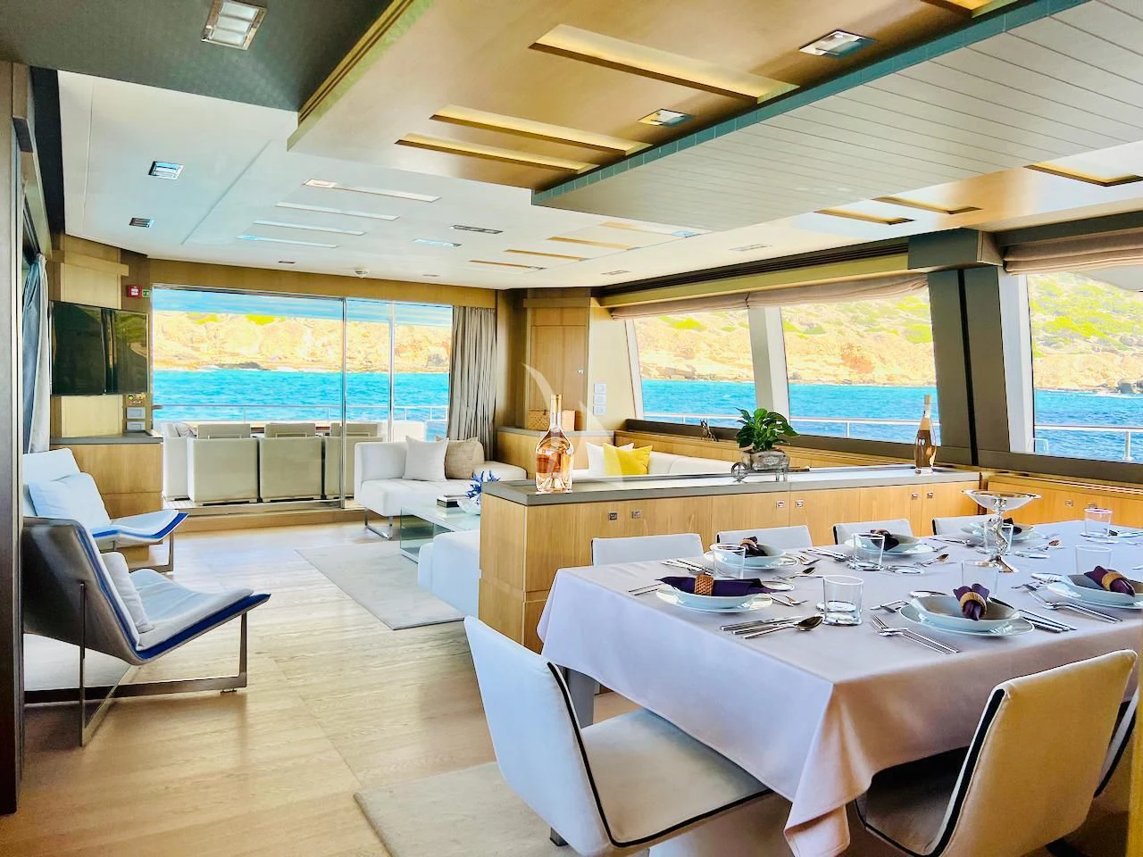 a large room with a table and chairs aboard NIKO III Yacht for Charter