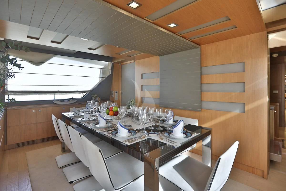 a table with chairs and a large window aboard NIKO III Yacht for Charter