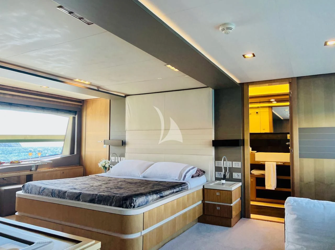 a bedroom with a bed and a window aboard NIKO III Yacht for Charter