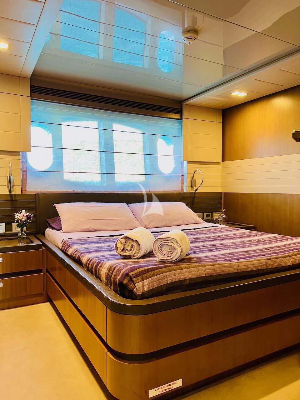 a bed with a purple comforter aboard NIKO III Yacht for Charter