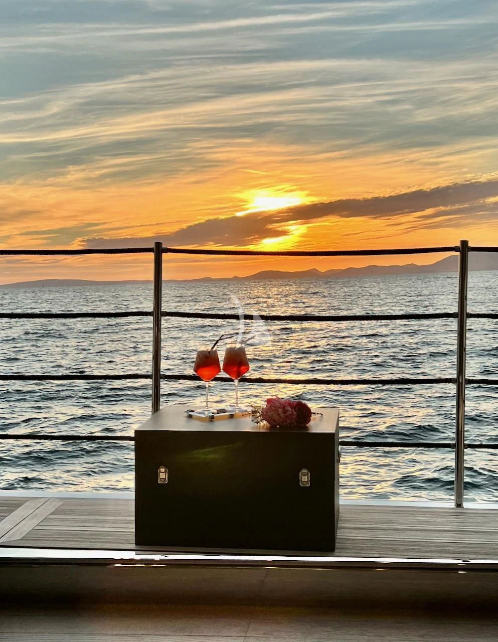 a sunset over a body of water aboard NIKO III Yacht for Charter