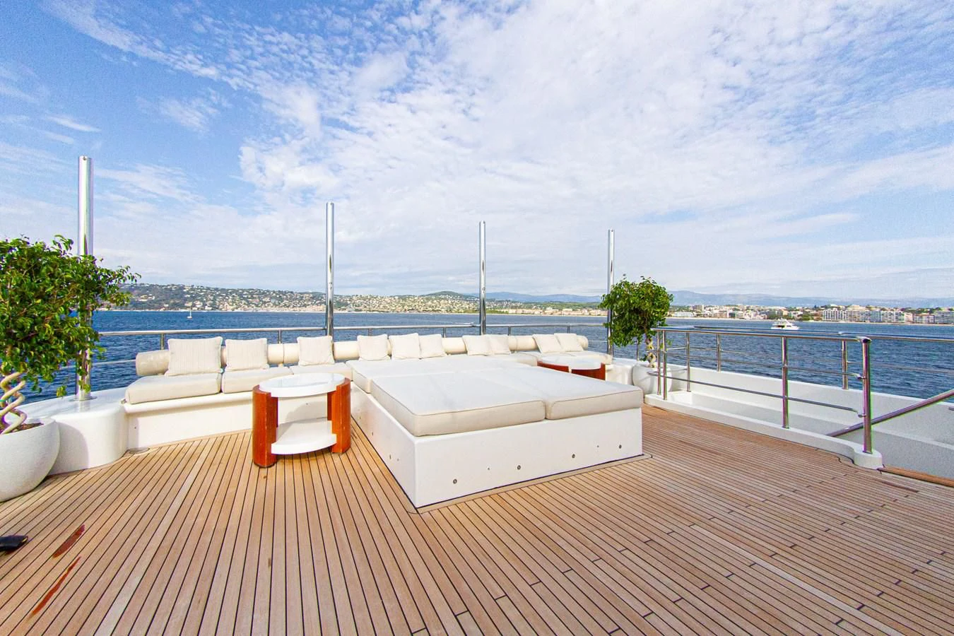 a white lounge chair on a deck overlooking a body of water aboard DARLING Yacht for Sale