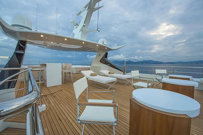 a deck with a table and chairs on it and a body of water in the background aboard DARLING Yacht for Sale
