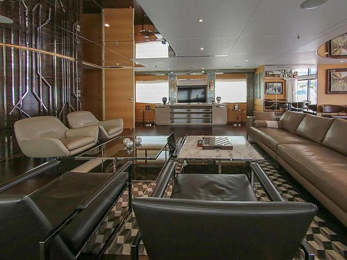 a living room with a large glass table and couches aboard DARLING Yacht for Sale