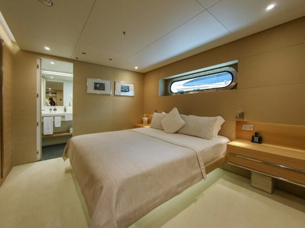 a bedroom with a bed and a wood staircase aboard DARLING Yacht for Sale