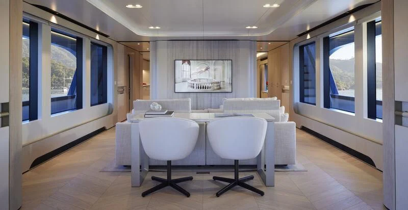 a room with white tables and chairs aboard LL Yacht for Sale