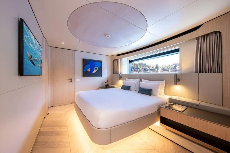 a room with a bed and a large window aboard LL Yacht for Sale