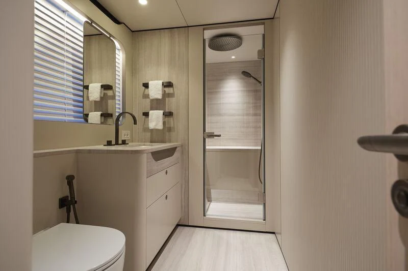 a bathroom with a glass shower door aboard LL Yacht for Sale