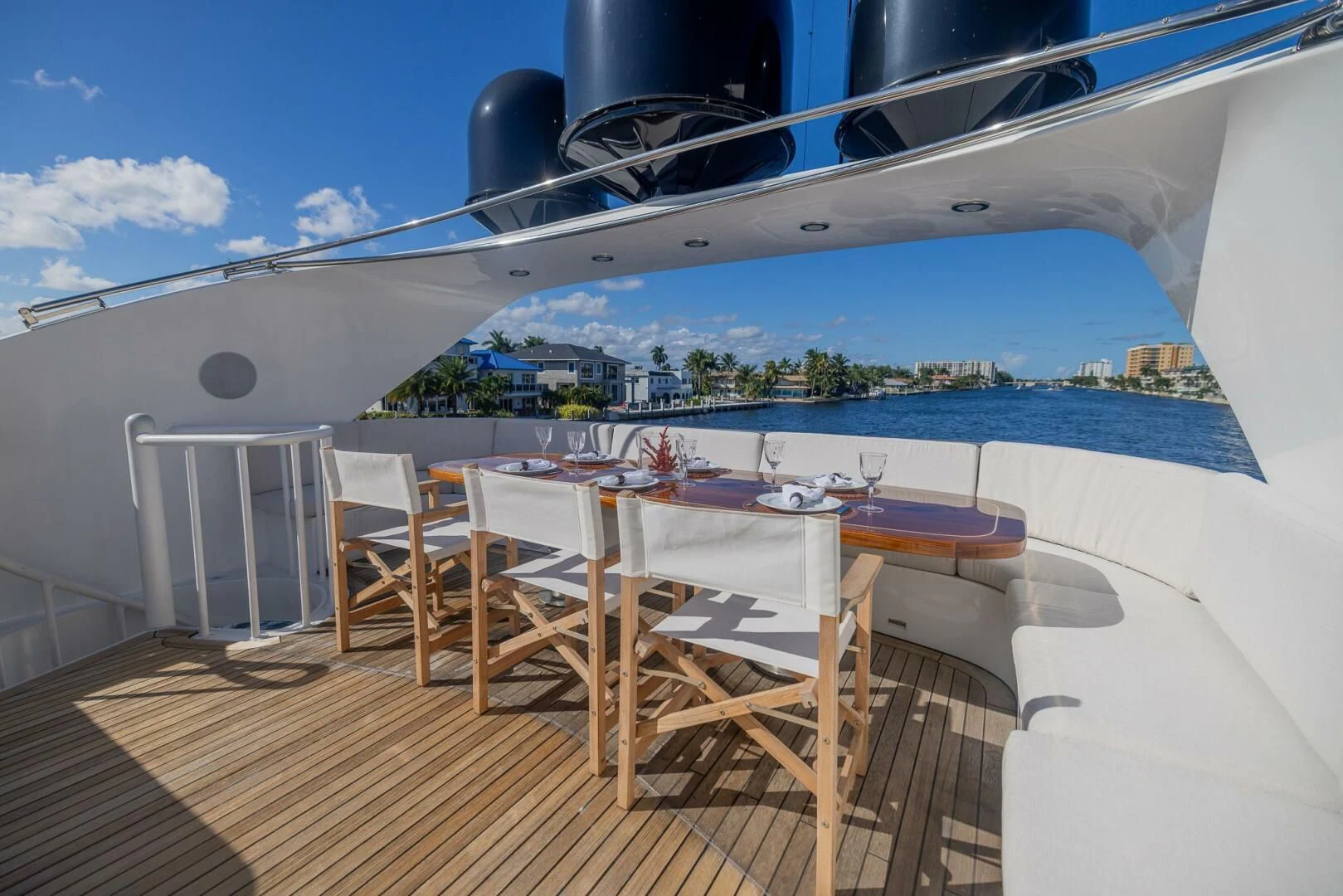 a deck with a table and chairs aboard ENTOURAGE Yacht for Sale