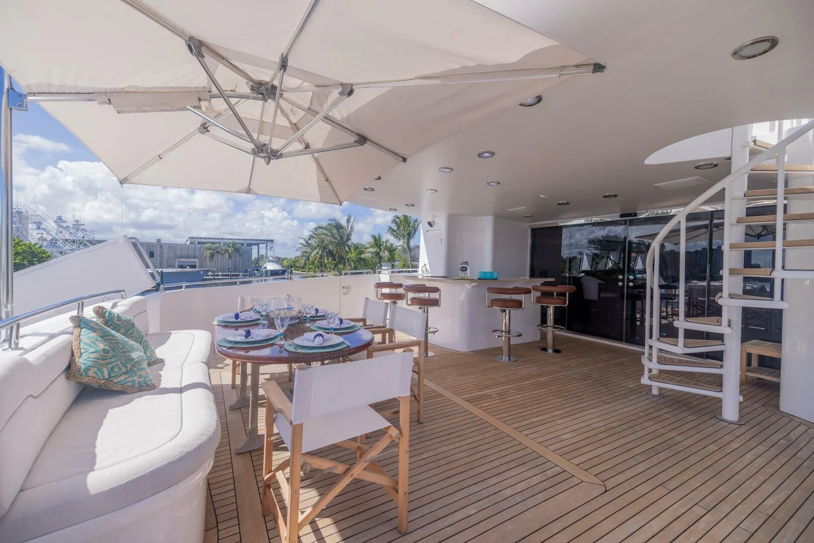a large open area with a table and chairs and a large building aboard ENTOURAGE Yacht for Sale