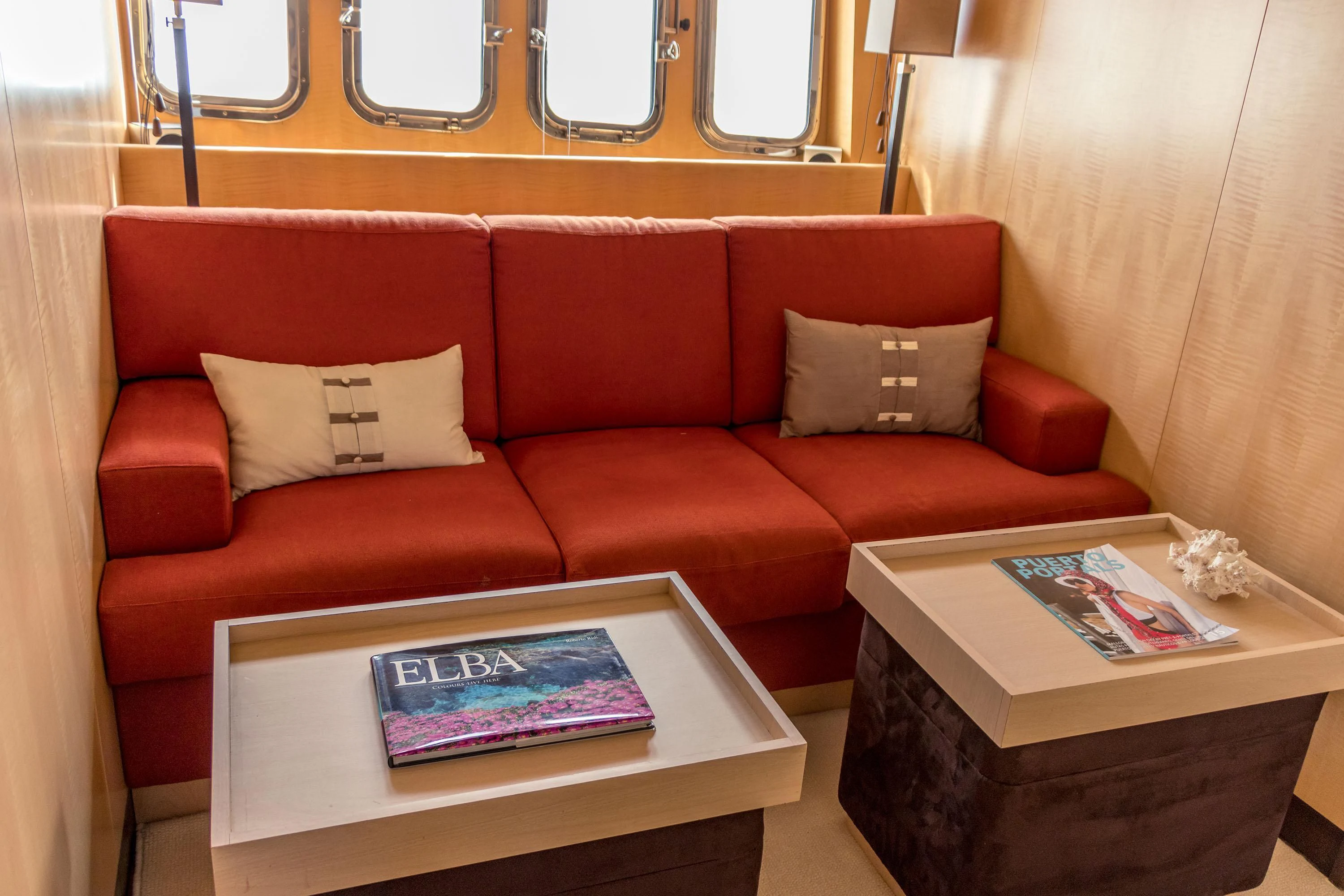 a red couch with a coffee table aboard VELOCE Yacht for Sale
