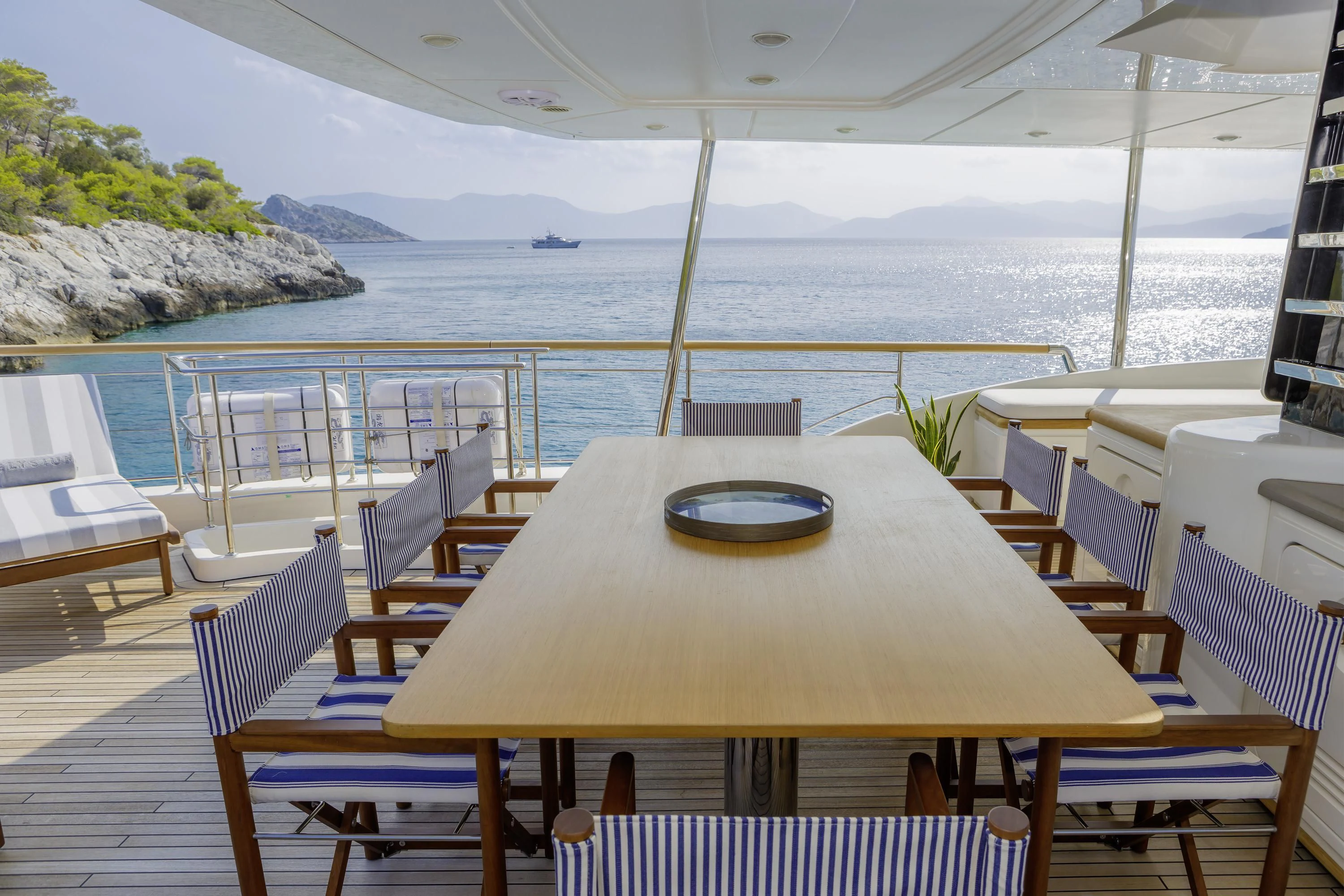 a table on a deck overlooking a body of water aboard ELYSIUM Yacht for Sale