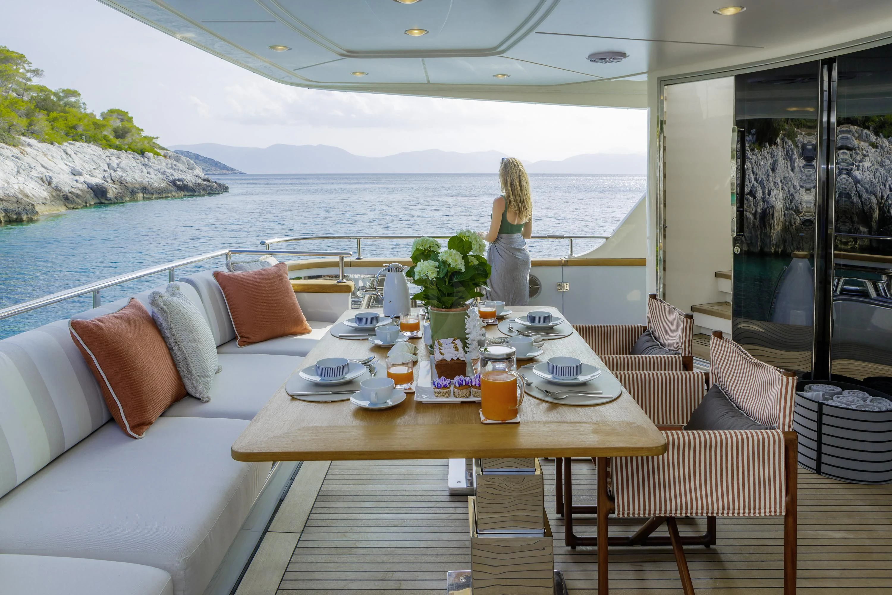a person standing on a balcony overlooking a large body of water aboard ELYSIUM Yacht for Sale