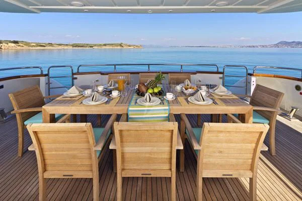 a table set for a meal on a deck overlooking the ocean aboard HELIOS Yacht for Charter