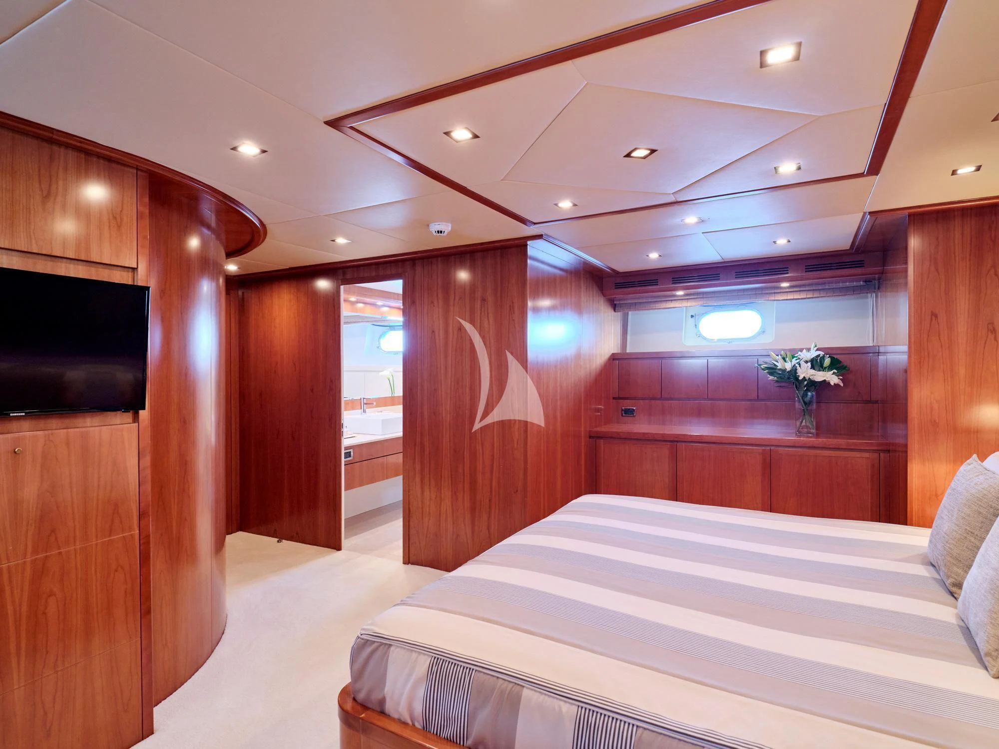 a room with a bed and a television aboard HELIOS Yacht for Charter