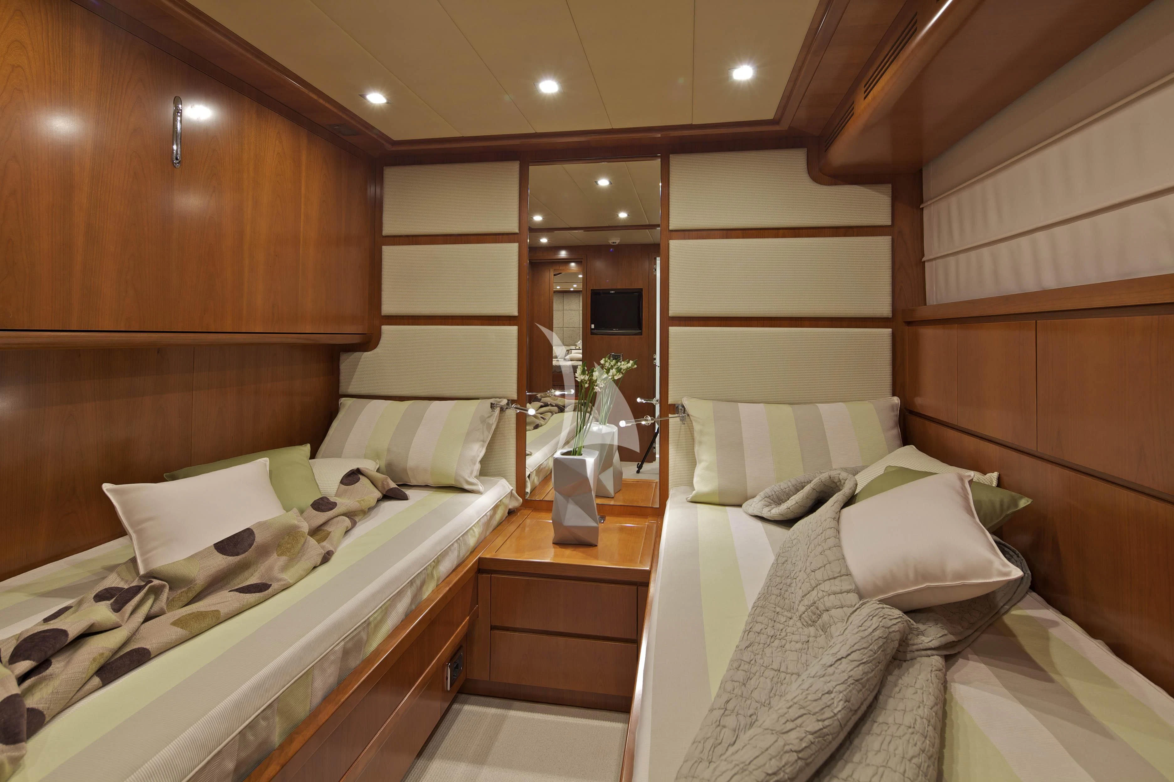 a room with beds and a mirror aboard HELIOS Yacht for Charter
