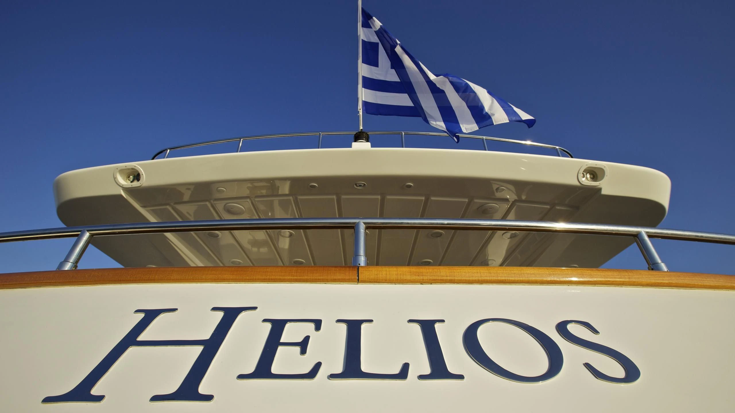 a boat with a flag on the front aboard HELIOS Yacht for Charter