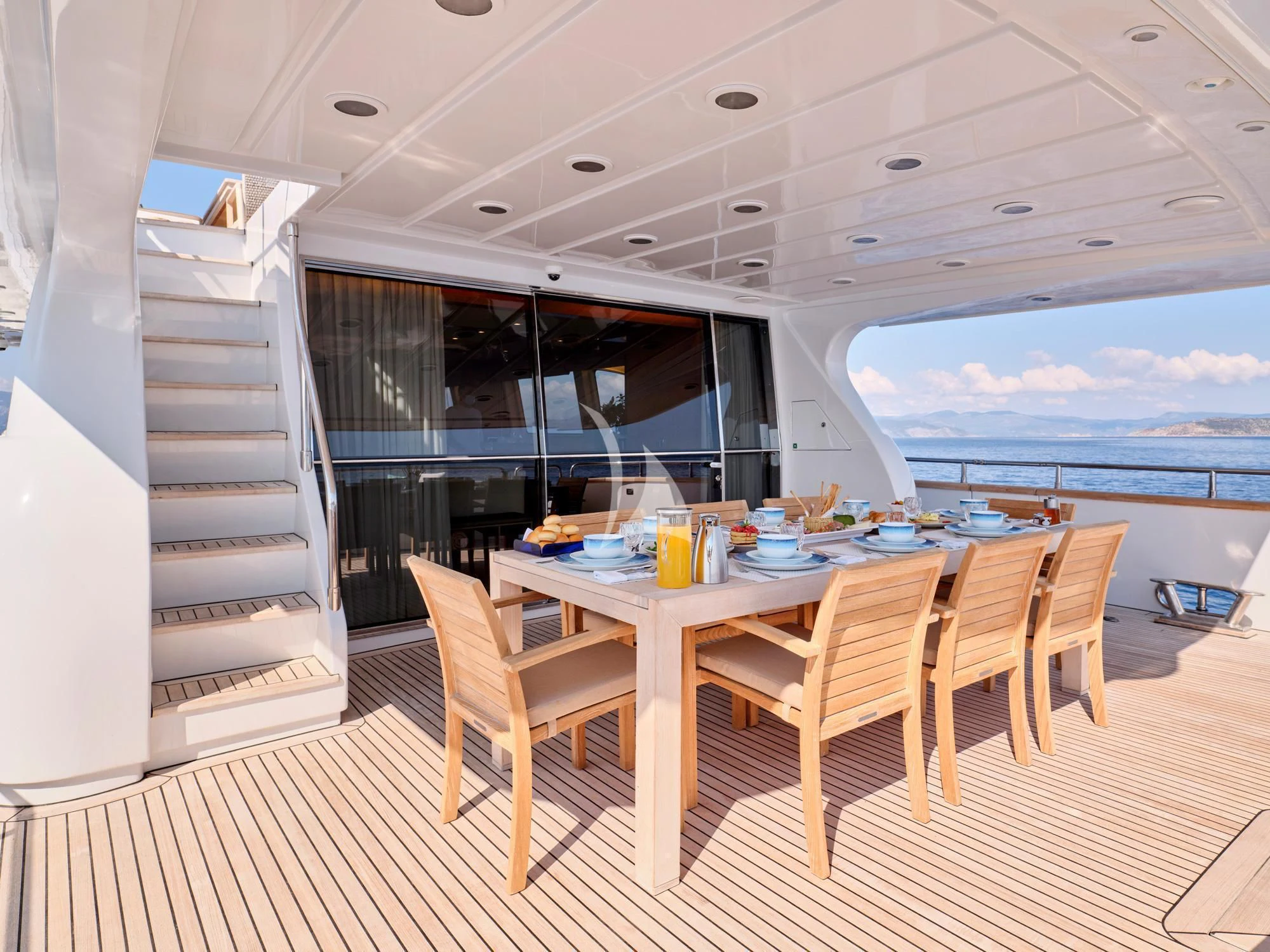 a table and chairs on a deck aboard HELIOS Yacht for Charter